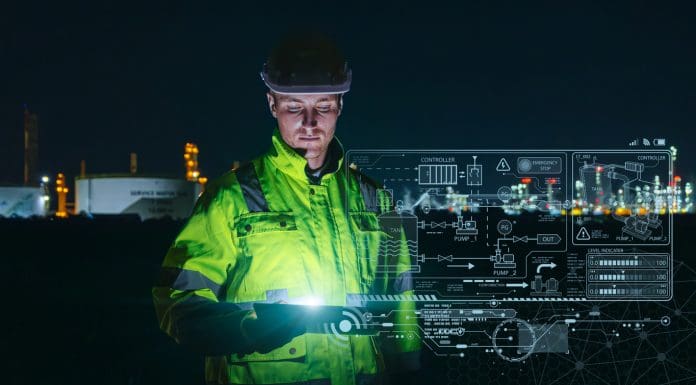 Modern technology oil and gas refinery engineer worker using advance digital device monitor service in petroleum industry pipe plant.