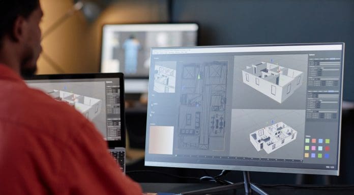 Man working on architectural designs on dual computer screens in an office environment. Concentrating on details of building layout and structure on screen