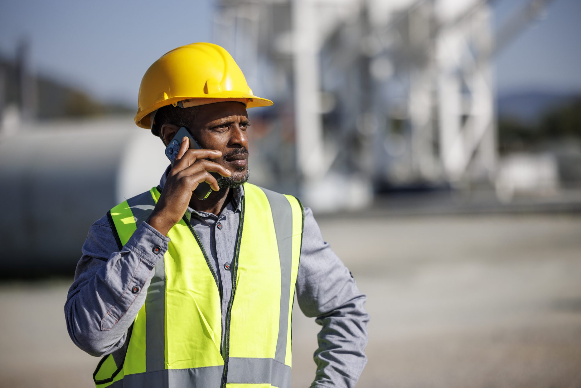 Assent Building Control collapse: causes, consequences, and industry challenges Project Manager Discussing Work Plans Over the Phone at a Construction Site, representing the Assent collapse