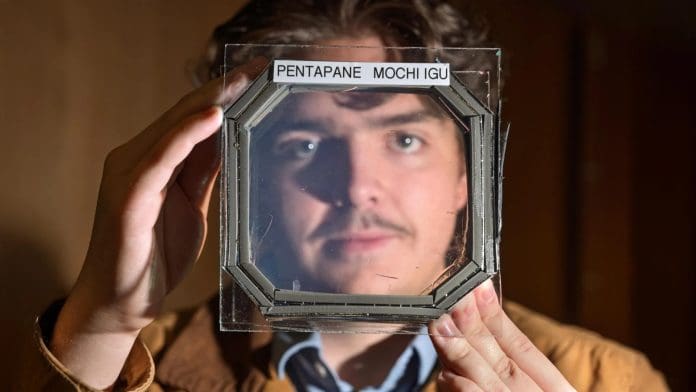 Abram Fluckiger holds up a sample panel square that has five sandwiched layers of a new material nearly transparent insulation material called MOCHI, which was designed buy CU Boulder researchers in physics professor Ivan Smalyukh’s lab. Credit: Glenn J. Asakawa/CU Boulder
