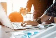 Access Coins and Payapps integration to transform construction industry payments Two architects co-worker working together on project and using laptop checking data at office room, representing payapps access construction