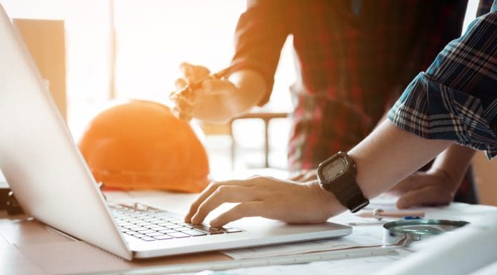 Two architects co-worker working together on project and using laptop checking data at office room, representing payapps access construction