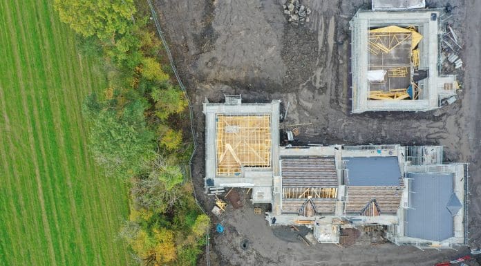 House development construction site in progress aerial view UK, representing building with nature