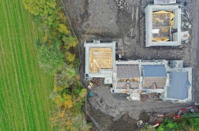 House development construction site in progress aerial view House development construction site in progress aerial view UK, representing building with nature