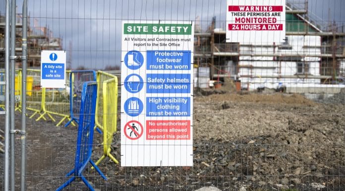 Construction site health and safety message rules sign board signage on fence boundary uk