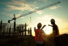 Deltek launches new sustainable growth formula to power next wave of UK SMB growth Silhouette of team engineer using laptop to control work, crane, construction site.