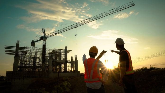 Deltek launches new sustainable growth formula to power next wave of UK SMB growth Silhouette of team engineer using laptop to control work, crane, construction site.