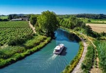 Actis becomes patron of UNESCO World Heritage site Aerial drone view of houseboat in Canal du Midi from above, family travel by boat, vacation in Southern France