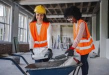 Continued government construction skills support needed, says report Two women working on a construction site loading cement bags into a wheelbarrow