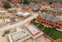 Cautious optimism: Housing outlook, mortgage rates – and what developers should do now Construction workers are busy building new homes in a suburban neighborhood. Various houses are taking shape, while others are in different stages of completion.