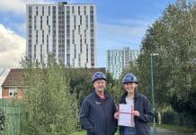 Pick Everard achieves fire safety assurance on Salford high-rise buildings Pick Everard employees standing outside one of the buildings with the fire safety assurance certificate