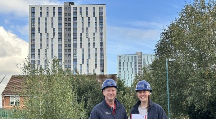 Pick Everard employees standing outside one of the buildings with the fire safety assurance certificate