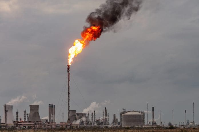 Oil refinery flare stack Environmental damage: A large flame and dark smoke rising from a flare stack at Grangemouth oil refinery and petrochemical plant in Scotland.