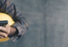 The email problem no one’s talking about in construction construction worker hands using smartphone on cement wall background with copy space