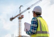 Tower crane drivers plan strike at end of month Engineering Consulting people on construction site holding blueprint in his hand and control workflow of the new building, representing the potential tower crane drivers strike