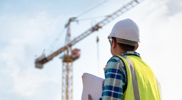 Engineering Consulting people on construction site holding blueprint in his hand and control workflow of the new building, representing the potential tower crane drivers strike