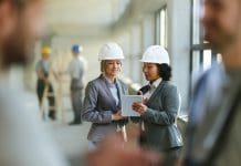 Ideagen launches free Email Management ROI Calculator: Calculate your cost savings in 30 seconds Female real estate developers cooperating while surfing the Internet on digital tablet at construction site, representing construction email management