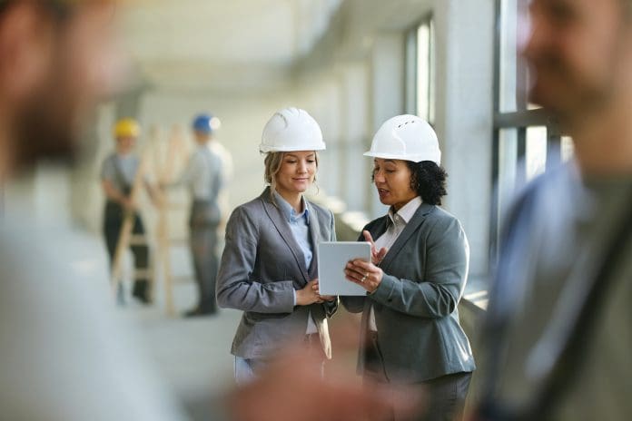 Ideagen launches free Email Management ROI Calculator: Calculate your cost savings in 30 seconds Female real estate developers cooperating while surfing the Internet on digital tablet at construction site, representing construction email management