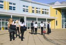Gleeds secures spot on DfE’s Technical Advisor Services framework Rear view of male and female students walking towards school entrance on way in to school, punctuality, good behaviour, order. School children walking to school, representing Technical Advisor Services 2025 framework