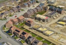 Industry welcomes Warm Homes Plan promise of £15bn for sustainable solutions Aerial view of new build housing with built in solar panels in the roof, England, representing changes proposed in the warm homes plan