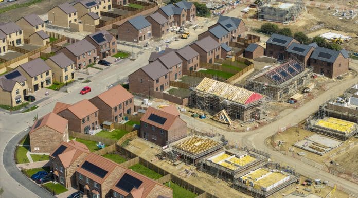 Aerial view of new build housing with built in solar panels in the roof, England, representing changes proposed in the warm homes plan
