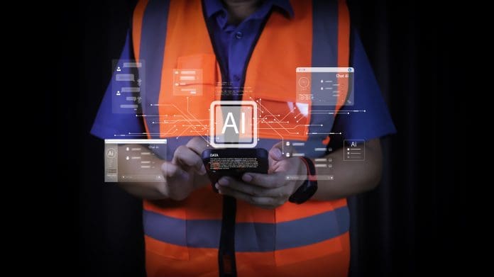 Industrial technician using mobile app to query data from AI chatbot. Smart factory worker consulting artificial intelligence for problem solving. Future construction communication. AI in construction is prophesised to bring productivity gains- but arguably the greatest transformation could lie in how risk is identified