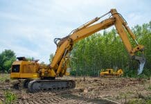 Why does UK construction fell thousands of mature trees each year? Mechanical Site Preparation for Forestry. Excavator and bulldozer clearing forest land.