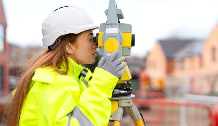 RLB 1 A female construction worker in hard hat and high vis looking through surveying equipment To meet government targets, we need people who are have the right skills, supported by technology and driven by a shared sense of purpose