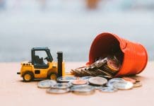 Cost pressures mounting for construction SMEs Closeup stack coins with construction vehicle using as business, industrial and financial concept