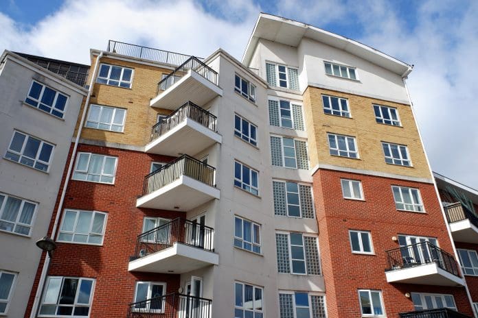 Modern high-rise apartment building Housing Committee says government must go further and faster on commonhold and leasehold reforms