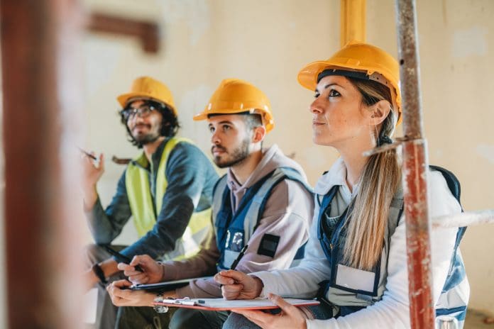 Three people are listening to their foreman on a construction site Closing the skills gap: Why construction training facilities are vital