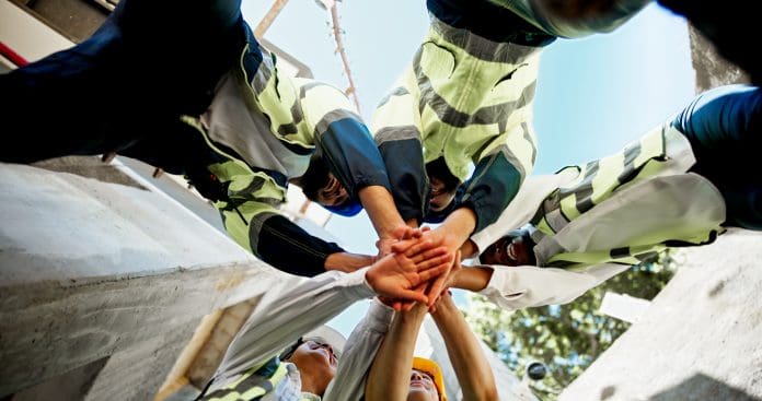 Construction, teamwork and hands together on site for support with building inspection and compliance success. Below, worker stack and people with celebration for project management and cooperation Construction, teamwork and hands together on site for support with building inspection and compliance success. Below, worker stack and people with celebration for project management and cooperation