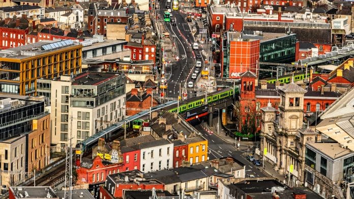 Aerial view of green Dart train in Dublin Ireland, Aerial view of crowded city life, european city centre, european cityscape, aerial crowded cityscape Irish construction market facing rising cost pressures and intensifying competition, report finds