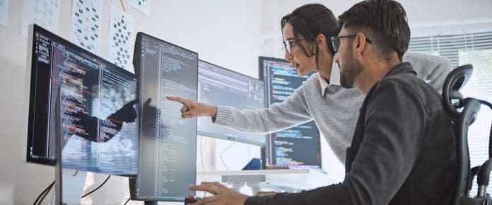 Hispanic Latin American couple, software engineer developer use computer, work on program coding together at home office. Programming language development technology, freelance job concept NFB welcomes government’s AI planning tools to ease department pressure