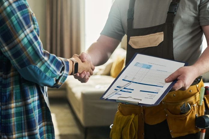 Caucasian Middle Aged Man Shaking Hands with Contractor Holding Invoice How impactful is trust in the construction industry?
