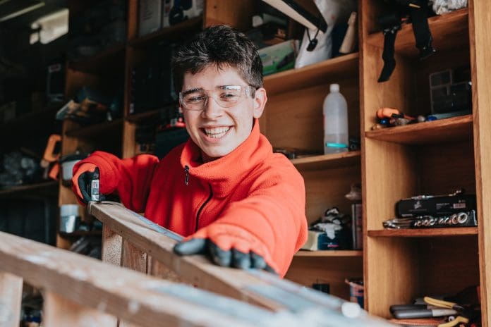 Smiling young man working in a workshop Education reforms will need more to implement construction skills pathways, say unions