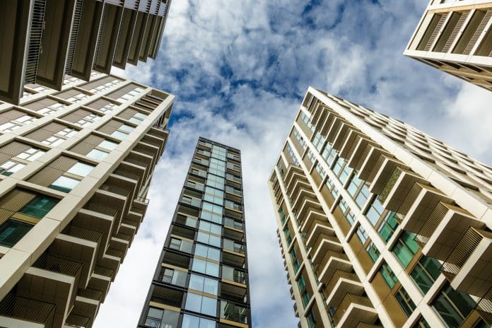 Low angle view of modern high rise apartment buildings in London, UK Unsafe cladding on lower-rise buildings will be addressed sooner with new funding
