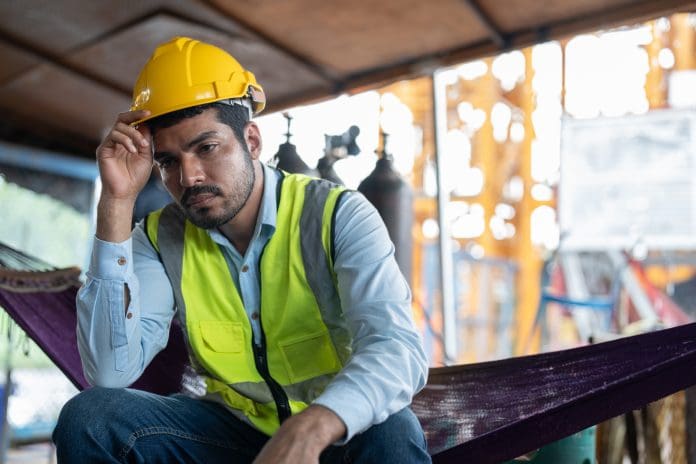 Asian man worker feeling tired while sitting at construction site. Construction doesn’t just have a recruitment problem – it has a burnout problem too