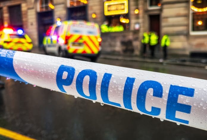 Police cordon tape during incident Close-up of police tape used as a temporary exclusion barrier while the police deal with an incident.