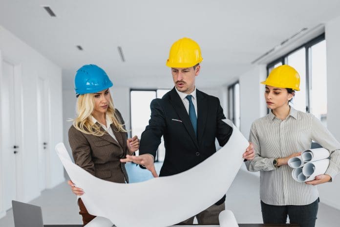 Business team of architects reviewing construction blueprints in empty office Construction’s leadership wish list for 2027
