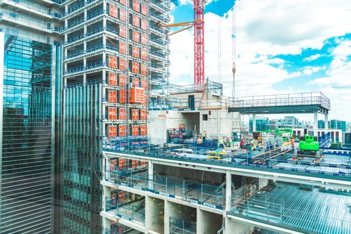 View at construction site with unfinished residential buildings against blue sky, London The UK built environment has a competence proof problem