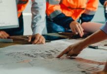 Why the built environment needs a viability rethink Closeup of team of industrial engineers meeting analyze machinery blueprints consult project on table in manufacturing factory. Working in manufacturing plant or production plant concept.