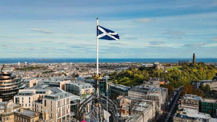 Aerial view of Edinburgh old town, aerial view of the scottish flag in Edinburgh, Edinburgh city centre, Gothic Revival architecture in Scotland, Flag of Scotland in Edinburgh Passivhaus Trust welcomes Scotland’s Passivhaus equivalent policy