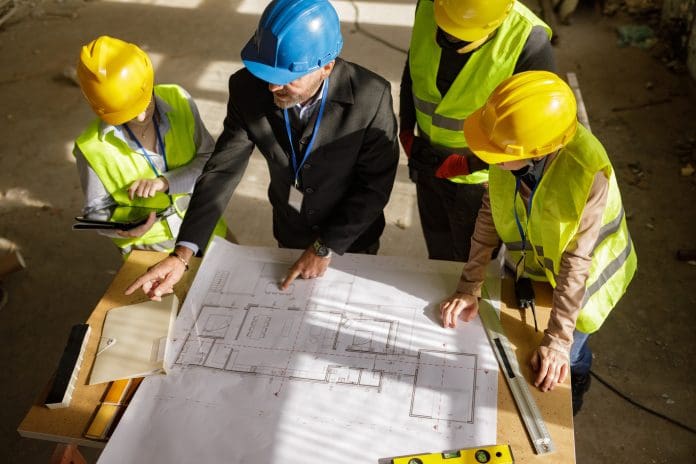 Architects Examining Construction Blueprints Construction and architecture apprenticeships up by 95% despite funding cuts