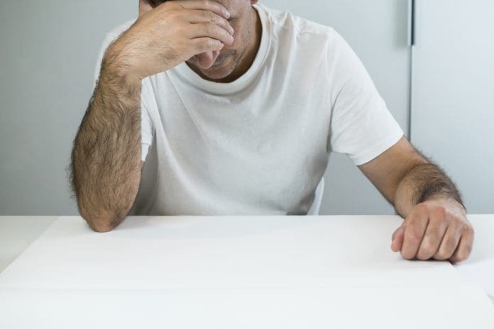 Overwhelmed adult male student touching forehead in despair Construction cashflow problems may be the sector's most overlooked issue