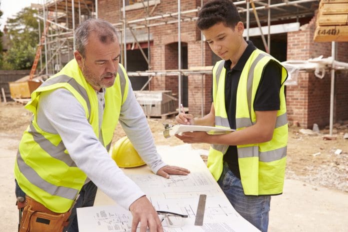 Builder On Building Site Discussing Work With Apprentice Construction in education would encourage a third of Londoners into the sector, say the FMB