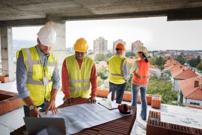 Colleagues analyzing project on construction site Social value is a win-win for construction businesses and communities