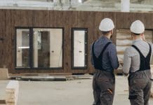No ecosystem, no industrialisation Two engineers are evaluating a finished prefabricated modular building inside a large factory, ensuring quality and compliance