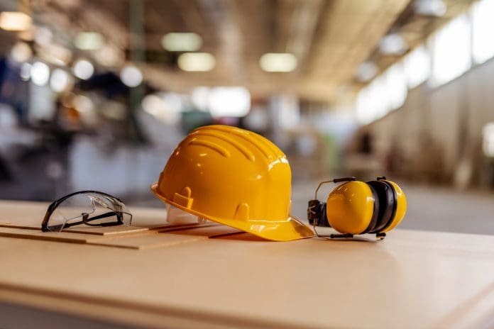 Yellow Hard Hat, Protective Glasses, and Earmuffs in Industrial Setting Appropriate PPE is a large part of building a construction culture of safety