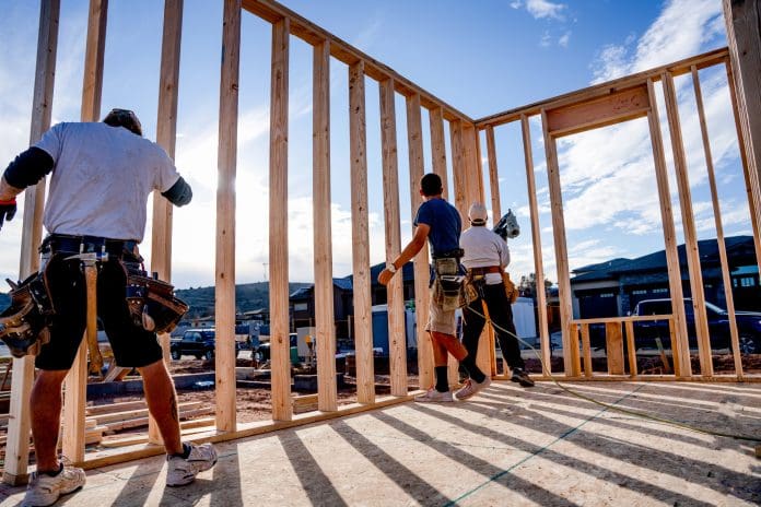 A Group Of Carpenters Setting Walls On A New Home Being Built In A New Single Family Housing, Subdivision Labour shortages are impacting construction projects, report finds